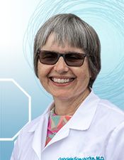 A woman in white lab coat and sunglasses.