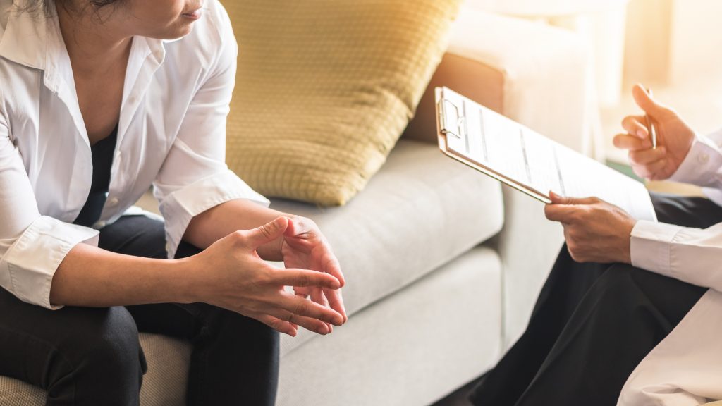 A person sitting on the couch talking to another person.