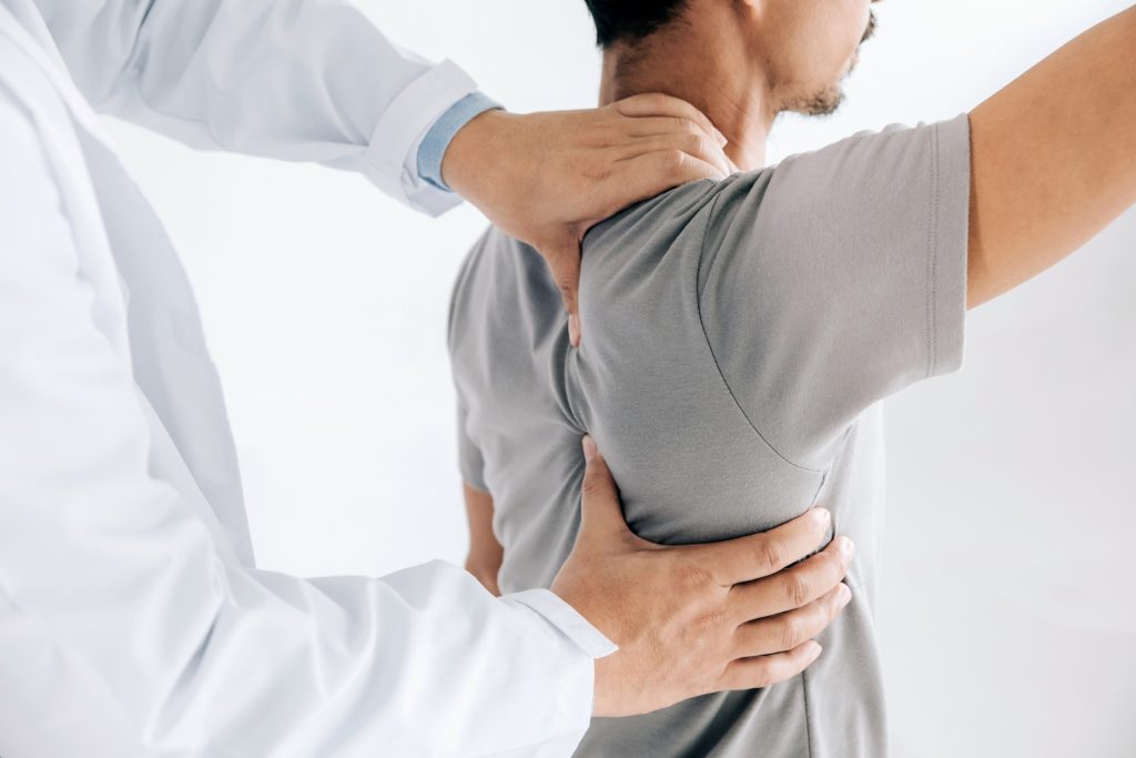 A person is getting their back checked by a doctor.