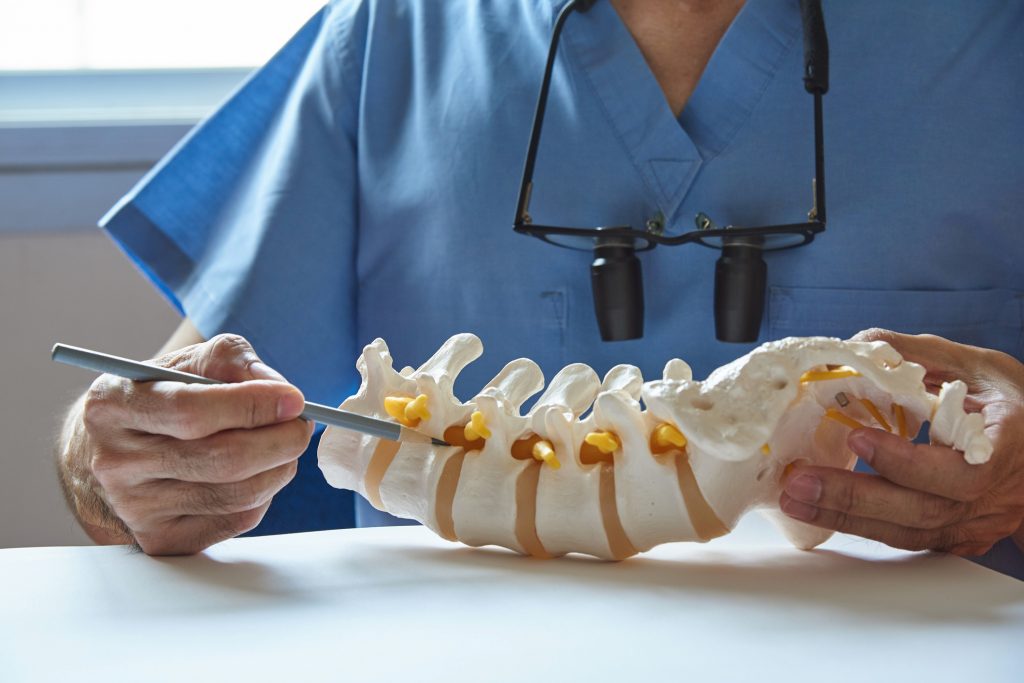 A doctor is cutting the spine of a patient.